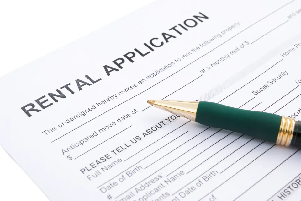Close-up of rental application laying on table with green pen laying across the paper